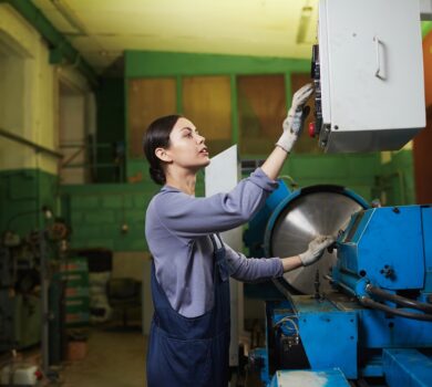 Female worker controlling the work of machine