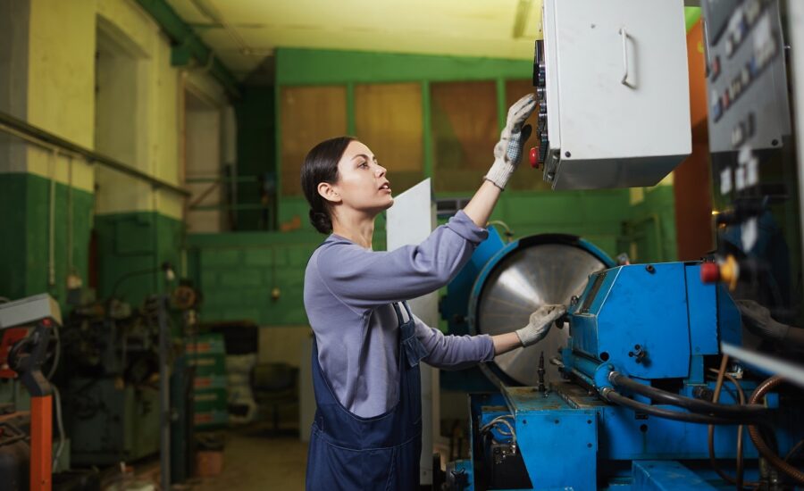 Female worker controlling the work of machine